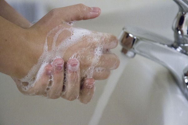 A student washes their hands to prevent spreading harmful bacteria.