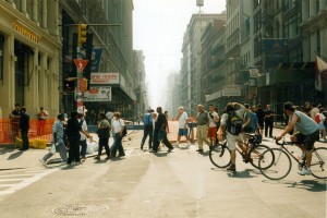 Surgical masks protect the pedestrians from the deadly dust. One man on a bike snaps a shot of an event that will change history.