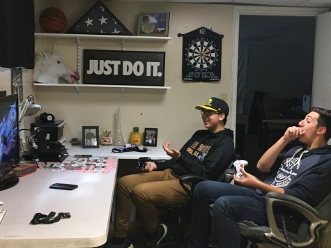 A pair of friends enjoy a video game together via couch play rather than through the online services.