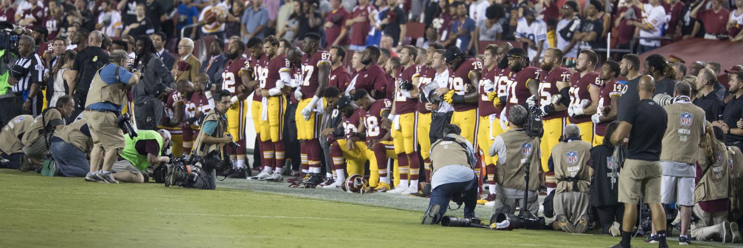 Washington Redskins players link arms during the national anthem as a show of protest following the president's speech.