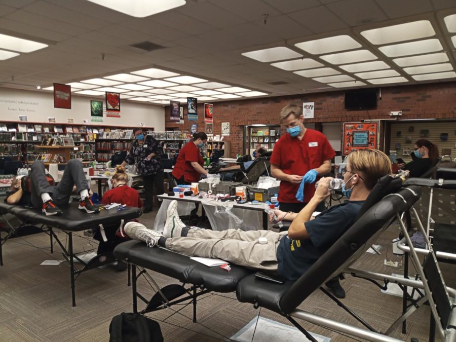 Medical Professionals helping students donate blood in the media center.