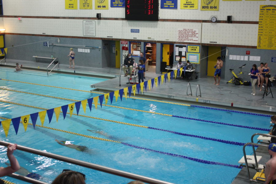 Taylorsville Highs swimming pool with three swimmers competing at a meet. 