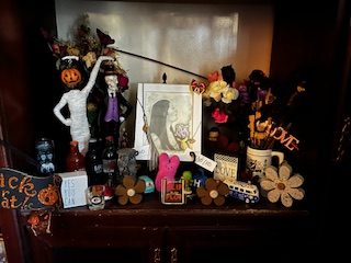 A picture frame on a shelf surrounded with objects that means value to the person in the picture.