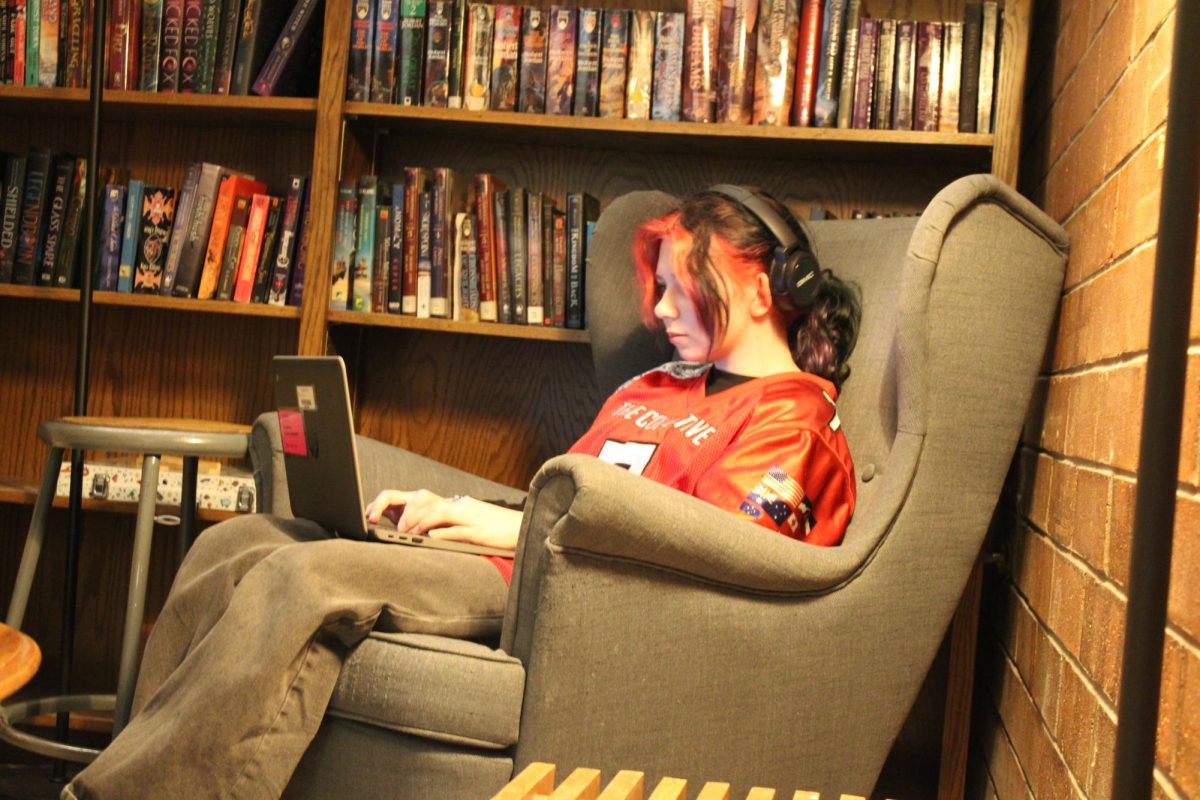 A student is listening to music while studying in Mr. Lore's classroom library.